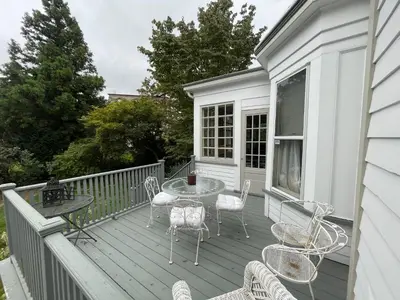 a deck with a table and chairs on a house at The White House in Plainfield
