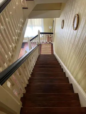 a staircase in a house with wooden stairs at The White House in Plainfield