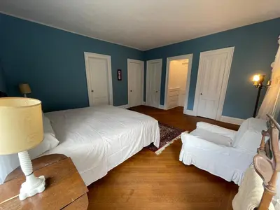 a bedroom with a white bed and a couch at The White House in Plainfield