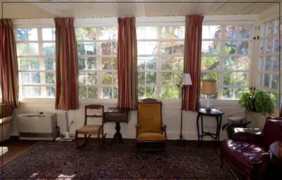 a living room with two chairs and large windows at The White House in Plainfield