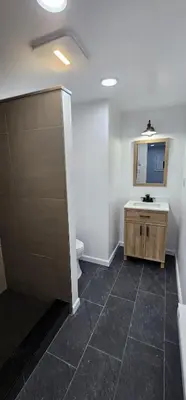 a bathroom with a sink and a toilet and a mirror at Aria Pocono Home in Tobyhanna