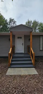 a house with a porch with a white door at Aria Pocono Home in Tobyhanna