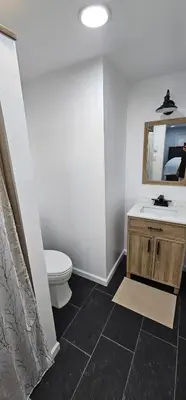 a bathroom with a sink and a toilet and a mirror at Aria Pocono Home in Tobyhanna