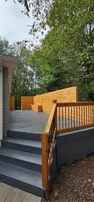 a wooden deck with stairs and a wooden fence at Aria Pocono Home in Tobyhanna