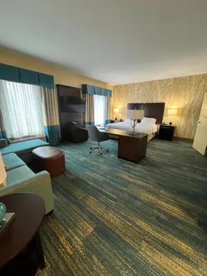 a hotel room with a bed and a couch at Hampton Inn & Suites Stroudsburg Bartonsville Poconos in Stroudsburg