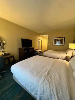 a hotel room with two beds and a flat screen tv at Hampton Inn & Suites Stroudsburg Bartonsville Poconos in Stroudsburg