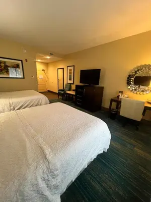 a hotel room with two beds and a flat screen tv at Hampton Inn & Suites Stroudsburg Bartonsville Poconos in Stroudsburg