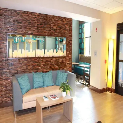 a living room with a couch and a brick wall at Hampton Inn & Suites Stroudsburg Bartonsville Poconos in Stroudsburg