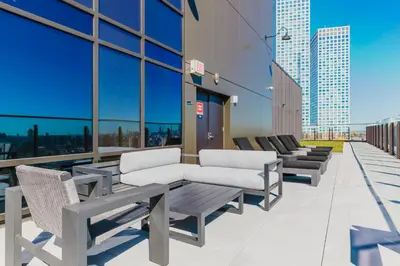 a balcony with chairs and tables on a building at Blueground Jersey City gym wd ac games NYC-1580 in New York