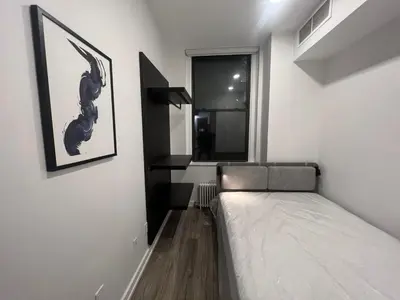 a small bedroom with a bed and a window at Luxury 2 BD unit in Financial District in New York