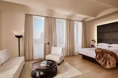 a bedroom with a bed and a couch and a chair at The New York EDITION in New York