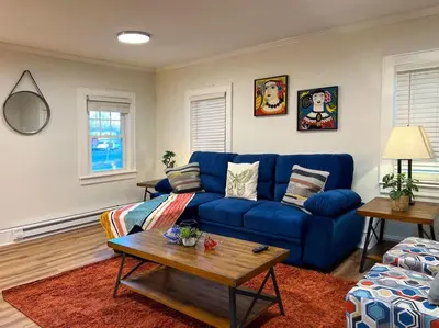 a living room with a blue couch and a table at Quaint Renovated Single Family in Matawan