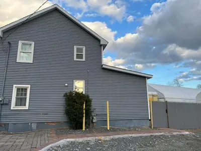 a gray house with a fence in front of it at Quaint Renovated Single Family in Matawan