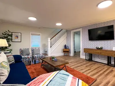 a living room with a blue couch and a flat screen tv at Quaint Renovated Single Family in Matawan