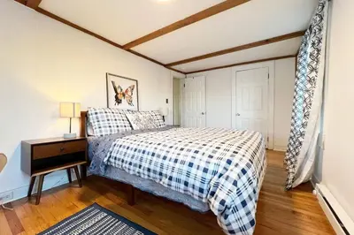 a bedroom with a bed and a night stand and a table at Quaint Renovated Single Family in Matawan