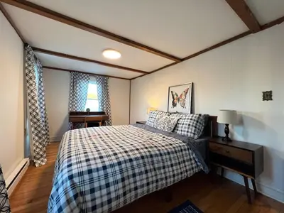 a bedroom with a bed with a checkered blanket at Quaint Renovated Single Family in Matawan