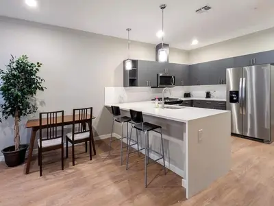 a kitchen with a refrigerator and a table and chairs at 213 Brand New 3 Bedroom 2 Bath 1 Full Kit 1 Liv in Dunellen