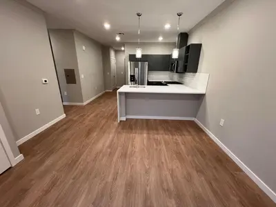 an empty room with a kitchen with wood floors at 322 Brand New 2 Bdr 1 KIT 2 BTH 1 LIV in Dunellen