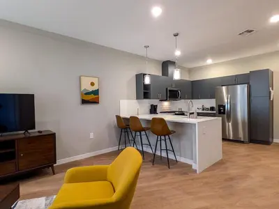 a kitchen with a yellow chair and a kitchen counter at 210 Brand New 1 Bedroom 1 Bath 1 Full Kit 1 Liv in Dunellen