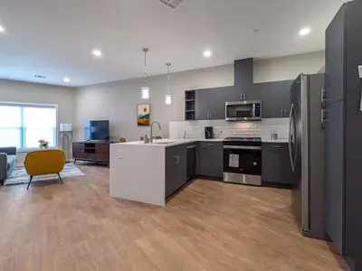 a kitchen with gray cabinets and a yellow chair at 210 Brand New 1 Bedroom 1 Bath 1 Full Kit 1 Liv in Dunellen