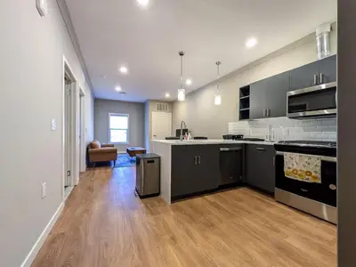 a large kitchen with black and white cabinets and wood floors at 324 Brand New 1 Bedroom 1 Bath 1 Kitchen 1 Liv in Dunellen