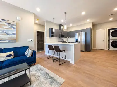 a living room with a blue couch and a kitchen at 222 Brand New 2 Bedroom 1 KIT 2 BATH 1 Living in Dunellen