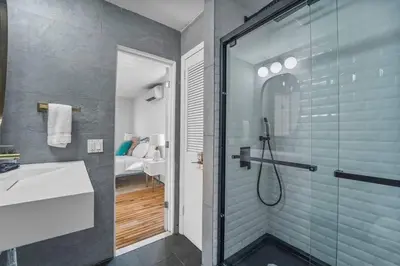 a bathroom with a glass shower and a sink at Luxe 10 guest Cottage Ski-Golf-Firepit-Lakes-Hike in Vernon Township