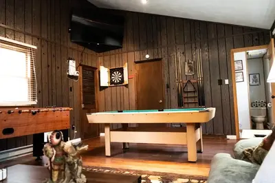 a living room with a pool table and a tv at Racc00ns Retreat in Lake Harmony