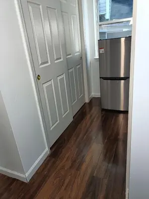 a kitchen with a refrigerator and a hard wood floor at Fada Guest House - 38 Yates Ave Newark in Newark