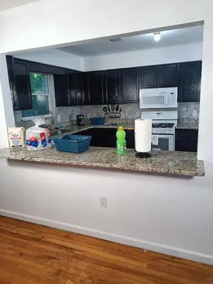 a kitchen with black cabinets and a counter top at Fada Guest House - 38 Yates Ave Newark in Newark