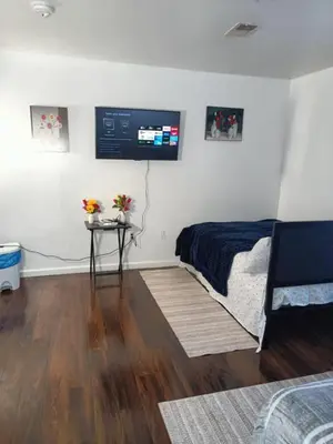 a bedroom with a bed and a tv on the wall at Fada Guest House - 38 Yates Ave Newark in Newark