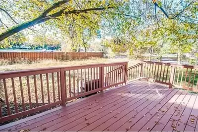a wooden deck with a tree and a fence at 107 Quaint Renovated Single Family 3 Bdrm House in Old Bridge