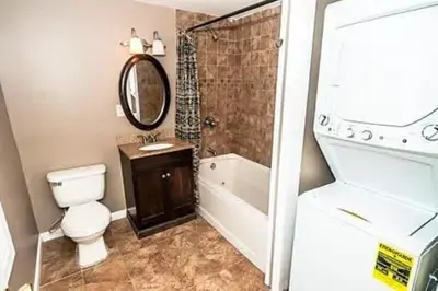 a bathroom with a toilet and a tub and a sink at 107 Quaint Renovated Single Family 3 Bdrm House in Old Bridge