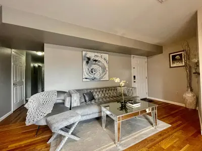 a living room with a couch and a table at 4 bedroom apt in Newark in Newark