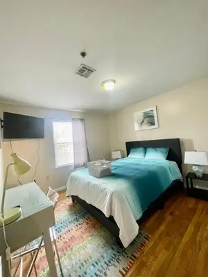 a bedroom with a bed and a table and a desk at 4 bedroom apt in Newark in Newark