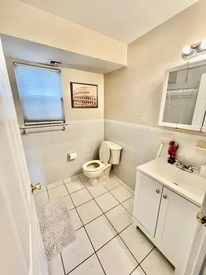 a white bathroom with a toilet and a sink at 4 bedroom apt in Newark in Newark