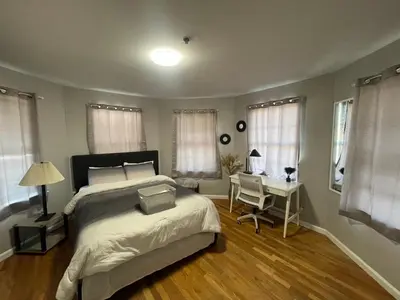 a bedroom with a bed and a desk and windows at 4 bedroom apt in Newark in Newark