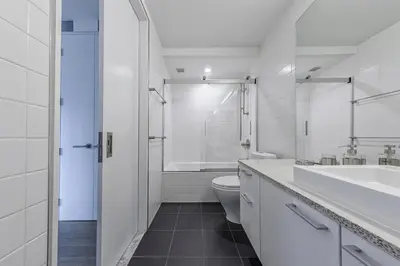 a white bathroom with a toilet and a sink at E Village 1BR w Doorman Gym nr Union Sq NYC-10 in New York
