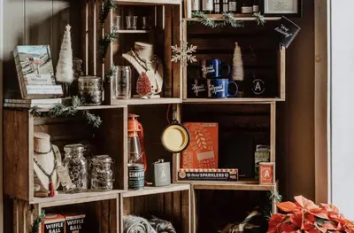 a wooden book shelf filled with christmas items at The Arnold House in Livingston Manor