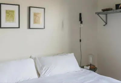 a bed with two white pillows and two pictures on the wall at The Arnold House in Livingston Manor