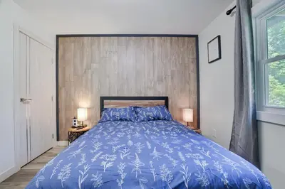 a bedroom with a blue bed with a wooden wall at 2 Bedroom Condo in Tannersville - 6 Minutes from Camelback Mountain in Tannersville