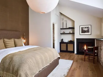 a bedroom with a large bed and a fireplace at Stockton Inn in Stockton