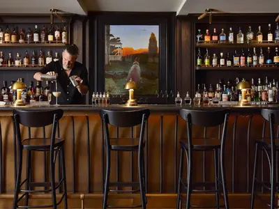 a man standing behind a bar with bottles of alcohol at Stockton Inn in Stockton
