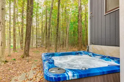 a jacuzzi tub sitting outside of a house at Home with Hot Tub and Arrowhead Lake Community Perks! in Pocono Lake
