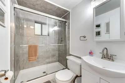 a bathroom with a shower and a toilet and a sink at Home with Hot Tub and Arrowhead Lake Community Perks! in Pocono Lake