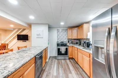 a kitchen with wooden cabinets and stainless steel appliances at Home with Hot Tub and Arrowhead Lake Community Perks! in Pocono Lake