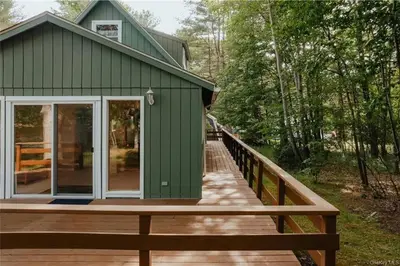 a green house with a wooden walkway leading to it at Lakefront with Lots of Light and Private Dock Access in Ferndale