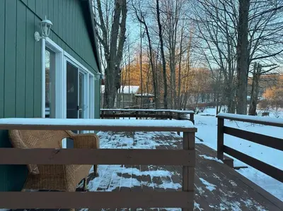 a snow covered bench next to a green building at Lakefront with Lots of Light and Private Dock Access in Ferndale