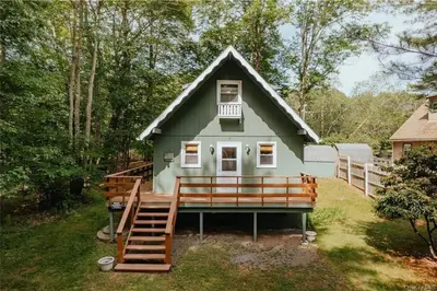 a tiny house with a porch and a staircase at Lakefront with Lots of Light and Private Dock Access in Ferndale
