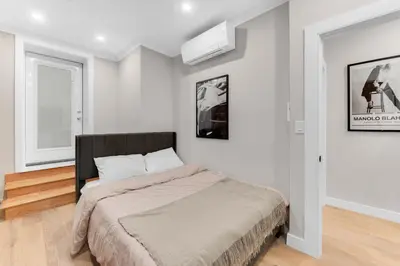 a bedroom with a bed with white walls at Modern 3Bd Rose Hills Manhattan Terrace Space in New York